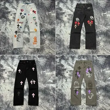 Four pairs of embroidered jeans laid on a grey backdrop