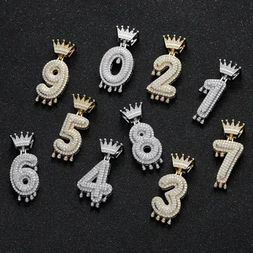 Crown-topped number pendants on a black velvet tray